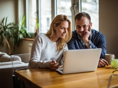 a man and woman (couple) looking at a laptop screen