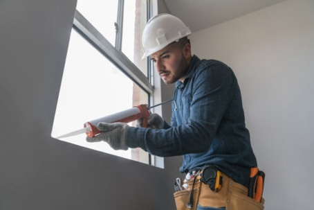 technician calking a window for better indoor air quality